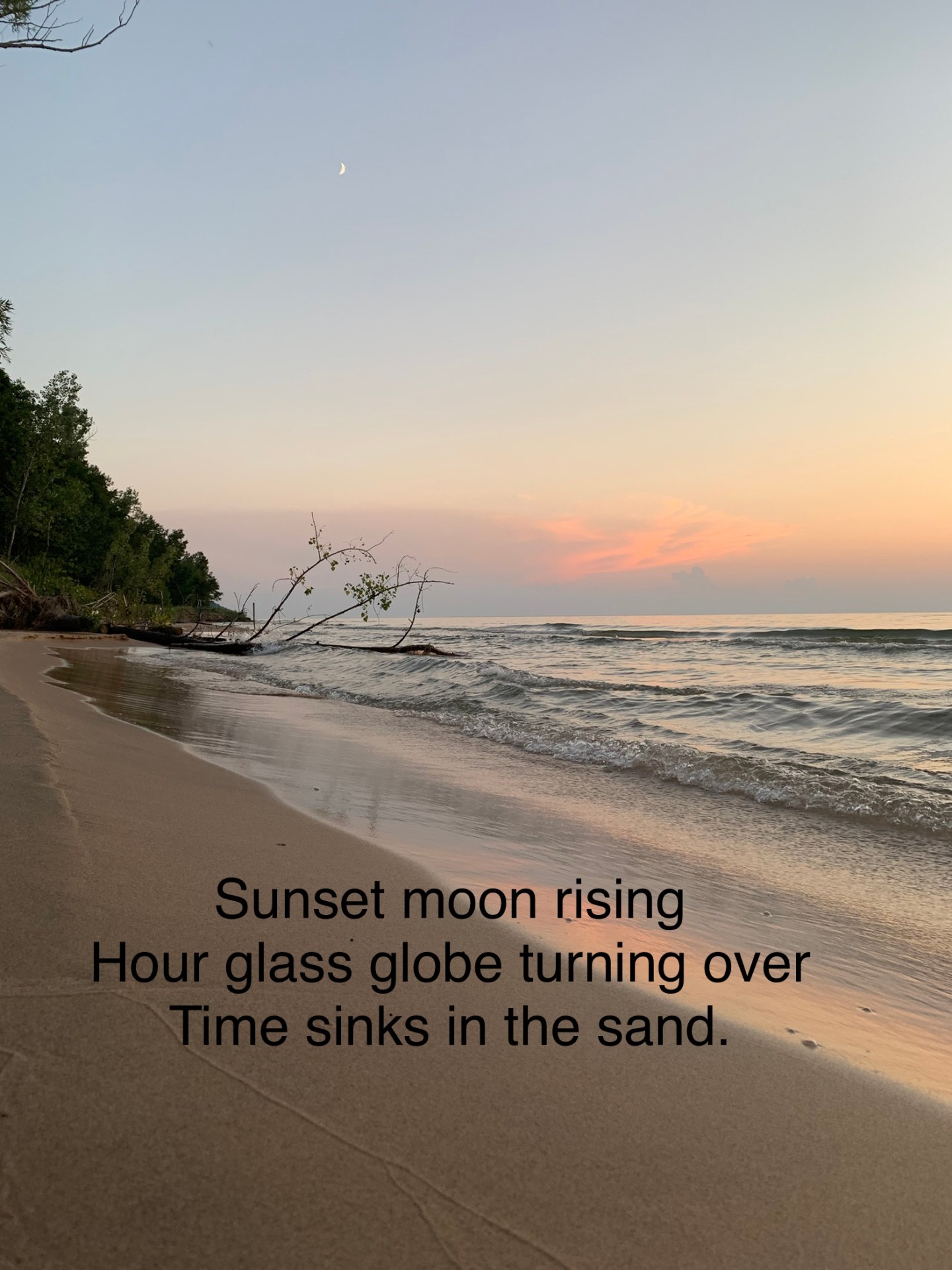 A crescent moon above a sunset shoreline. Phoem: Sunset moon rising / Hour glass globe turning over / Time sinks in the sand.